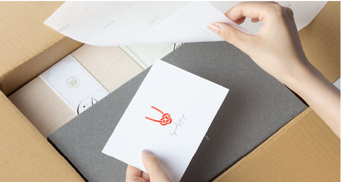 丁寧に梱包され段ボールに収まった引き出物と水引メッセージカード